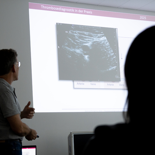 Kursraum mit Referent vor einer Leinwand. Auf der Leinwand ist ein Ultraschall-Bild zu sehen.