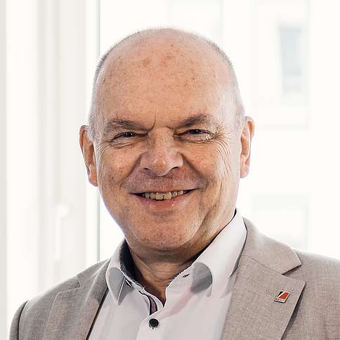 Peter Andreas Staub Portrait Peter Andreas Staub: höheres Alter, Halbglatze, Sakko, Krawatte. Er lächelt in Kamera.