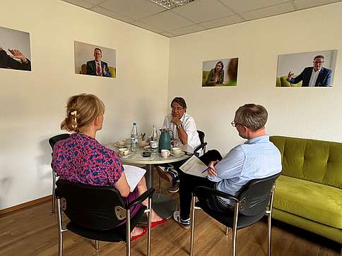 Dr. Bartels beim Sommerinterview Zwei Männer und eine Frau sitzen an einem runden Tisch und unterhalten sich.